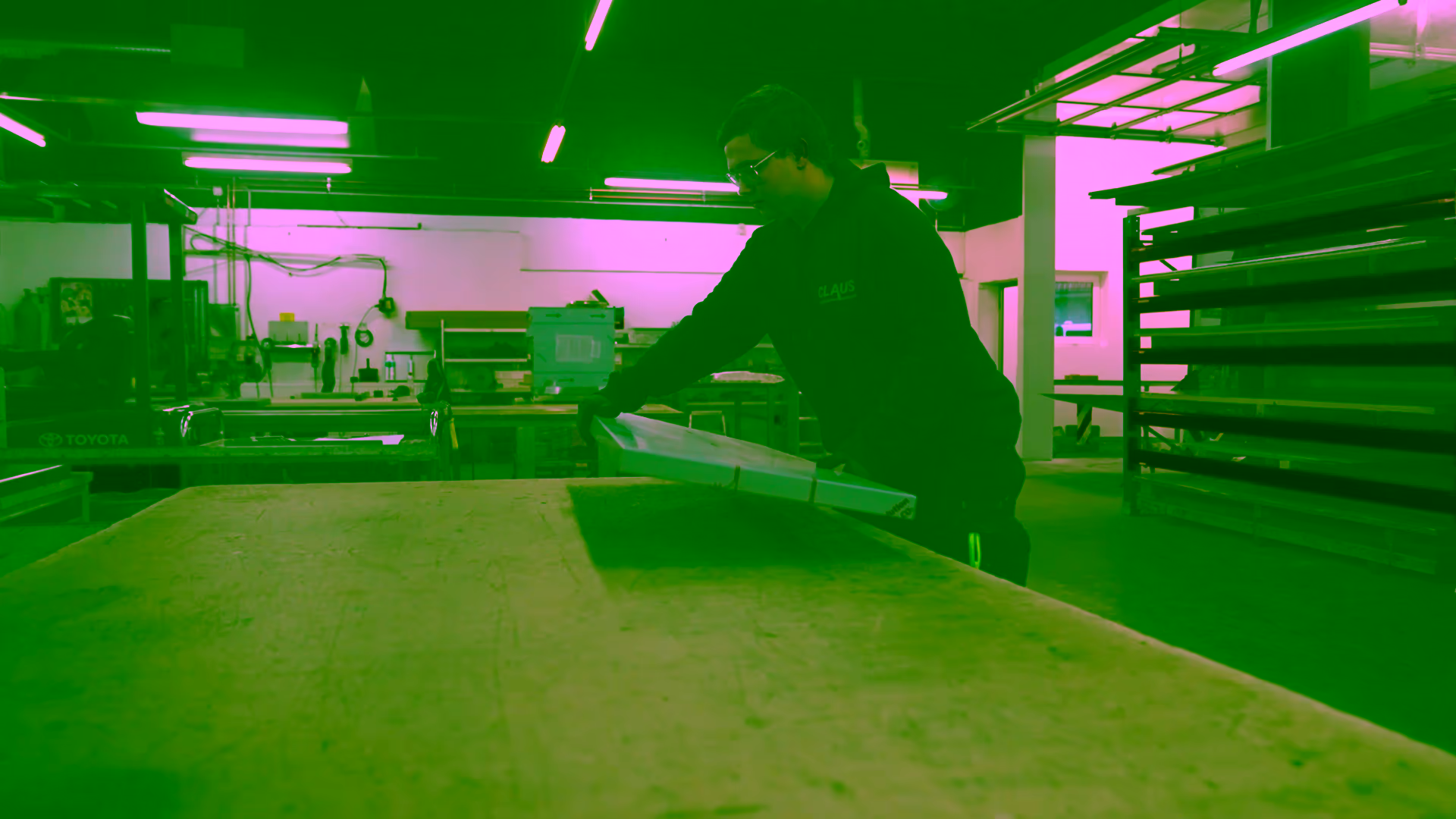 Werkstattsituation mit Blechtafel auf der Werkbank und Wandregal
